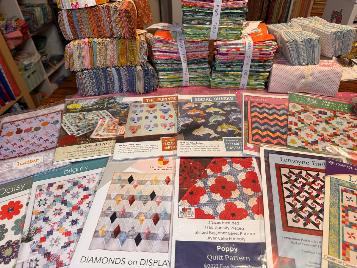 A table spread of quilt pattern packages at Bayou Quilt Co.