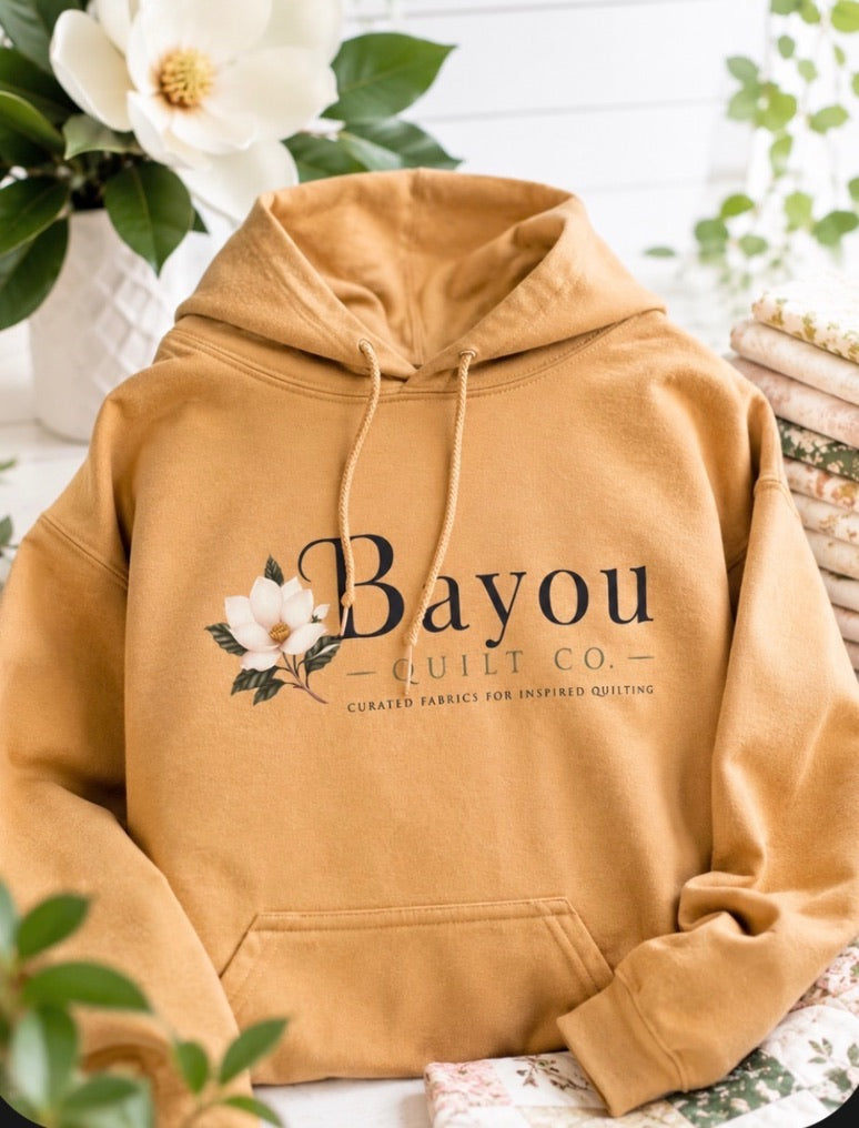 Bayou Quilt Co. hooded sweatshirt with horizontal logo, available in Old Gold and Sand