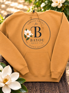 Bayou Quilt Co. hooded sweatshirt with round seal logo, available in Old Gold and Sand
